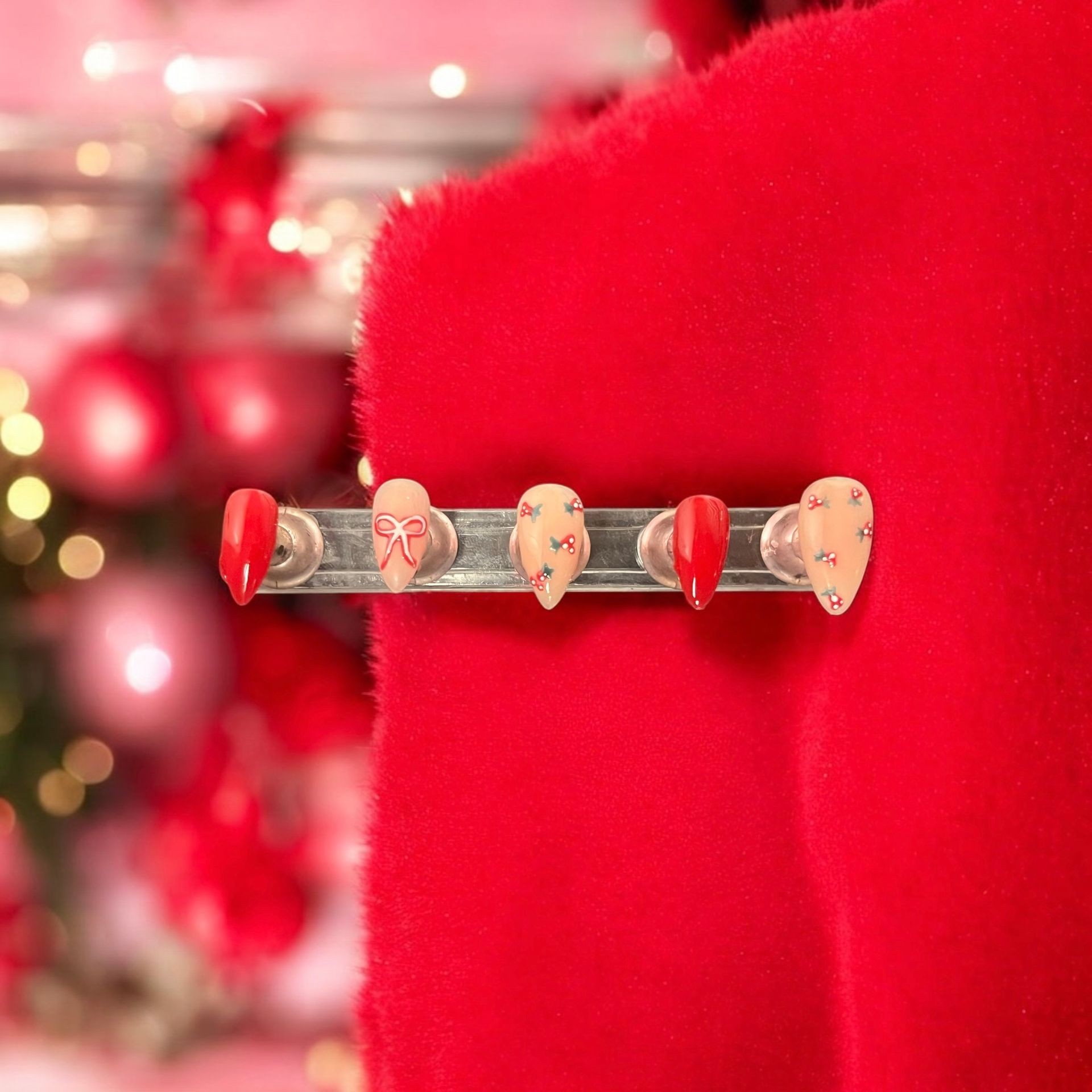 Festive Christmas-themed nail designs displayed on a red velvet background.